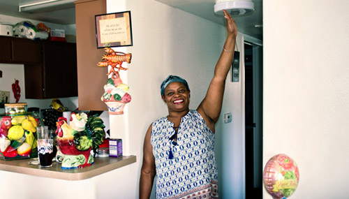United Way veteran beneficiary Marva Lewis touching the roof in her home